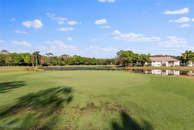 surrounding community with a water view and a yard