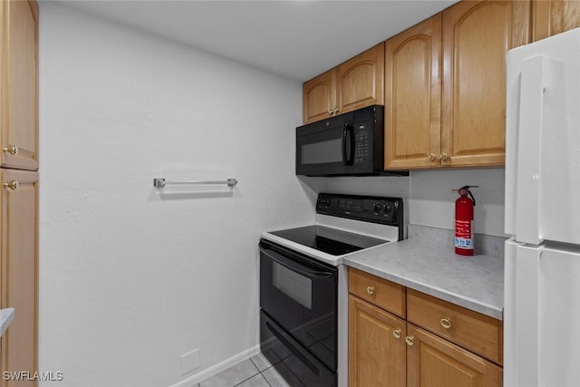 kitchen with light tile patterned flooring, white fridge, and electric range