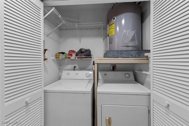 clothes washing area featuring electric water heater and washing machine and dryer