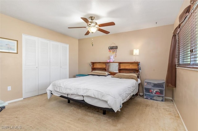 bedroom with light colored carpet, a closet, and ceiling fan