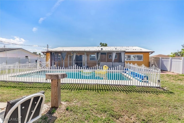 view of pool with a sunroom and a yard