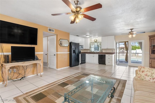 tiled living room with sink, a textured ceiling, and ceiling fan