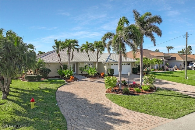 ranch-style home with stucco siding, an attached garage, decorative driveway, and a front lawn