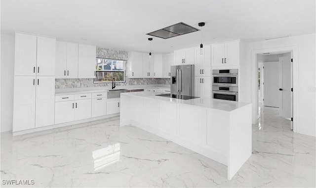 kitchen with white cabinetry, appliances with stainless steel finishes, a center island, and hanging light fixtures