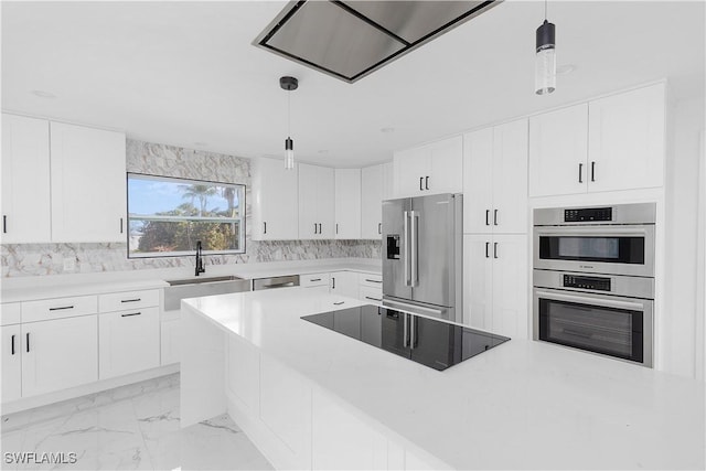 kitchen featuring stainless steel appliances, hanging light fixtures, and white cabinets