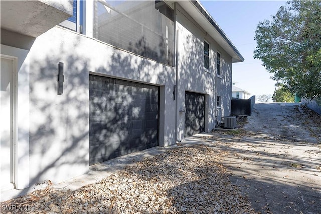 view of side of home with a garage and central AC