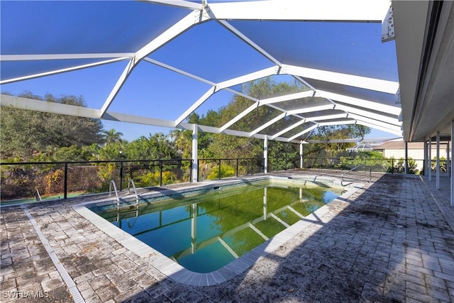 view of swimming pool with glass enclosure and a patio area