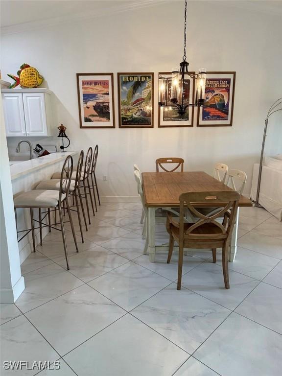 dining area with ornamental molding and an inviting chandelier