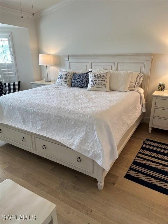 bedroom featuring crown molding and light hardwood / wood-style floors