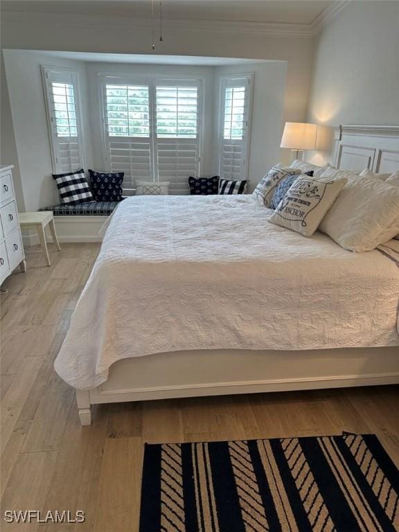 bedroom featuring light hardwood / wood-style flooring and ornamental molding