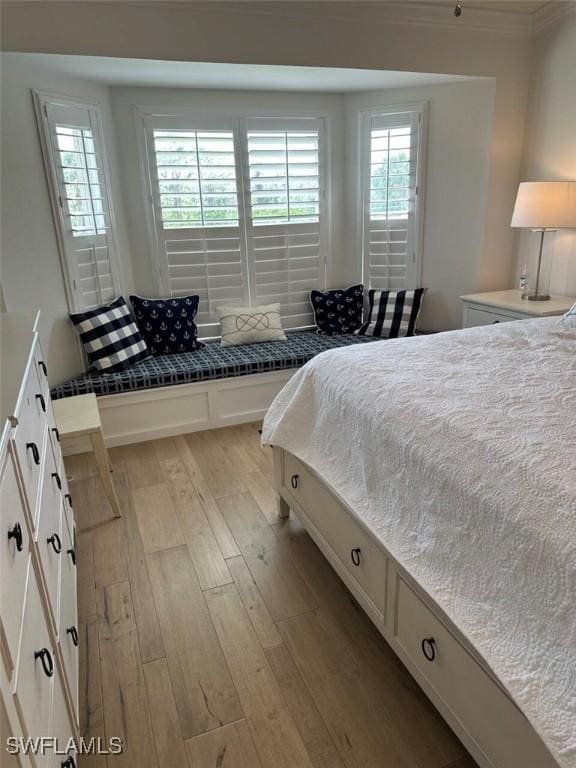 bedroom with light wood-type flooring and crown molding