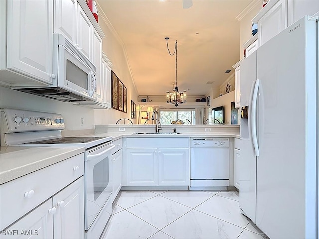 kitchen featuring white appliances, a sink, light countertops, white cabinets, and a notable chandelier