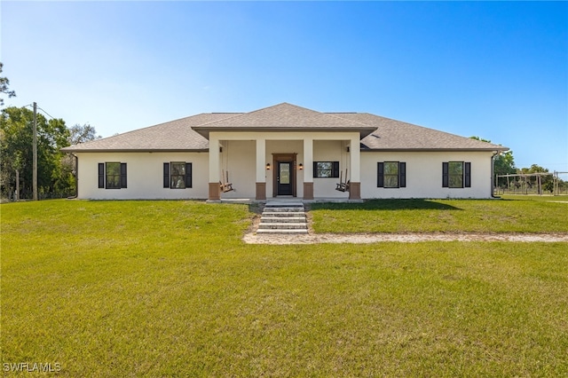 view of front of property featuring a front yard, a porch, roof with shingles, and stucco siding