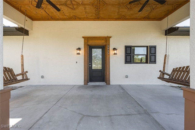 property entrance featuring stucco siding and ceiling fan