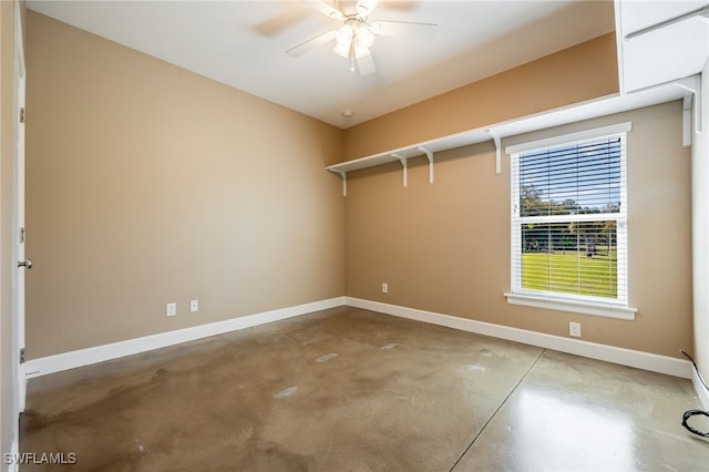 spare room with a ceiling fan, baseboards, and concrete floors