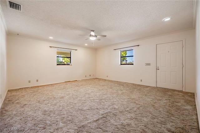 carpeted spare room with visible vents, a textured ceiling, recessed lighting, crown molding, and ceiling fan