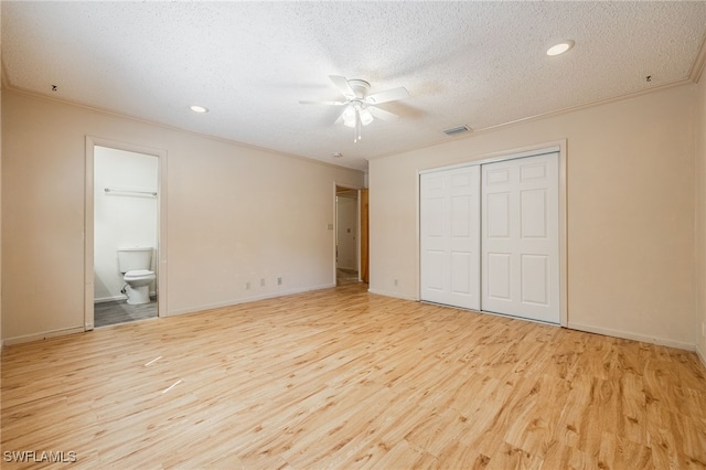 unfurnished bedroom featuring light wood-type flooring, visible vents, a closet, and ornamental molding