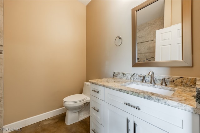 bathroom with vanity, toilet, and baseboards