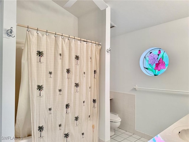 bathroom with curtained shower, tile walls, vanity, toilet, and tile patterned floors