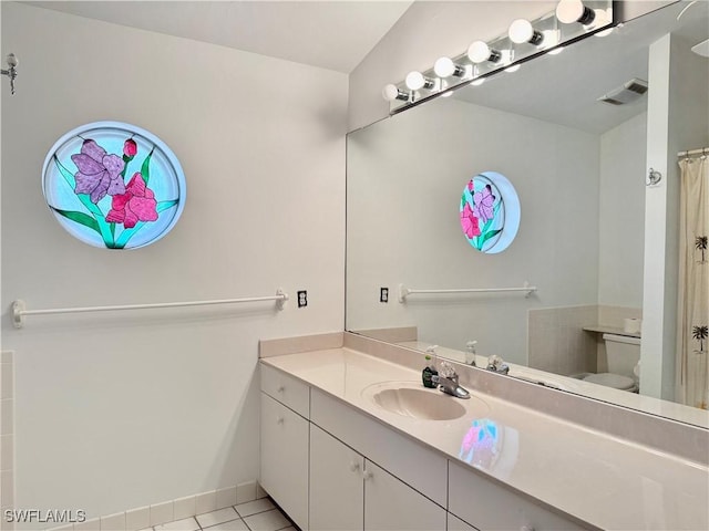 bathroom featuring tile patterned floors, vanity, and toilet