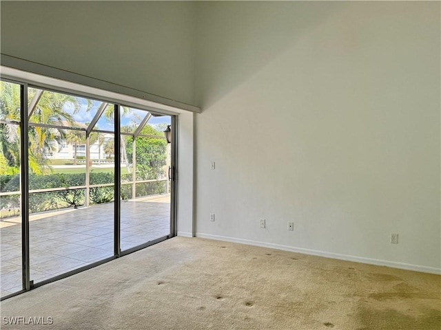 unfurnished room featuring carpet flooring and a towering ceiling