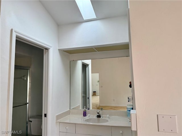 bathroom featuring vanity, toilet, and a skylight