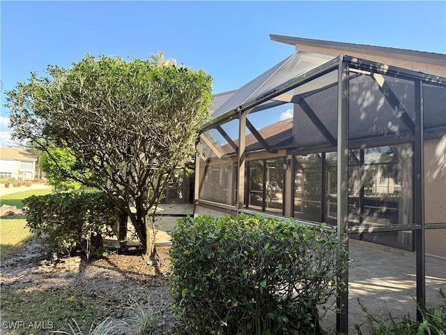 view of patio featuring glass enclosure