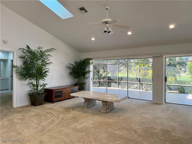 interior space with a skylight, plenty of natural light, high vaulted ceiling, and ceiling fan