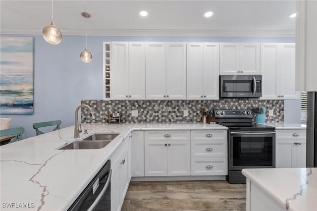 kitchen with stainless steel appliances, hanging light fixtures, sink, and white cabinets