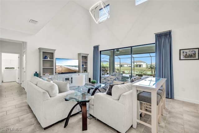 living room with washer / clothes dryer and high vaulted ceiling