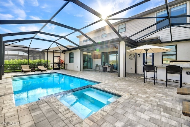 view of swimming pool featuring an in ground hot tub, a lanai, and a patio area