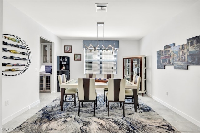 dining space with light tile patterned floors, beverage cooler, and a chandelier