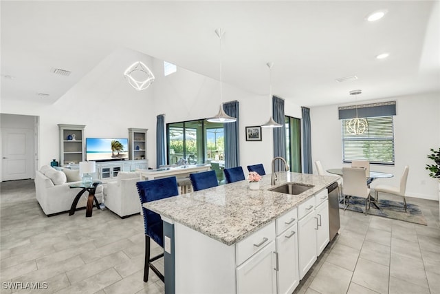 kitchen with a kitchen breakfast bar, a kitchen island with sink, sink, and white cabinets