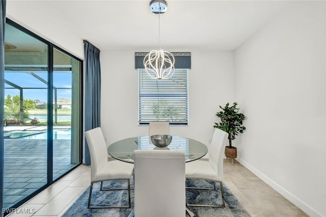 tiled dining room featuring plenty of natural light and a chandelier