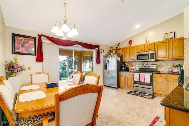 kitchen featuring vaulted ceiling, hanging light fixtures, appliances with stainless steel finishes, a notable chandelier, and backsplash