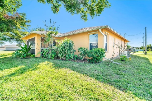 view of side of home with a yard