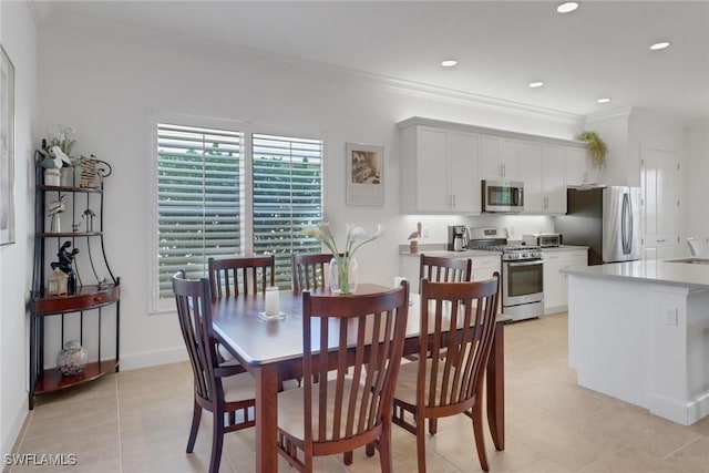 dining space with crown molding, sink, and light tile patterned floors