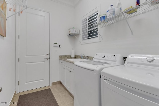 washroom with sink, light tile patterned floors, cabinets, and independent washer and dryer