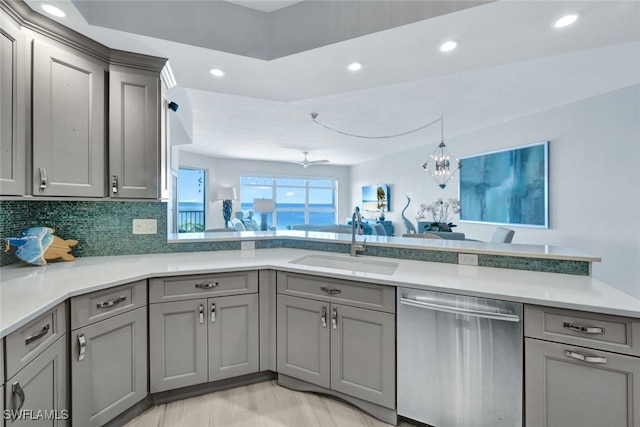 kitchen with sink, backsplash, gray cabinets, and dishwasher