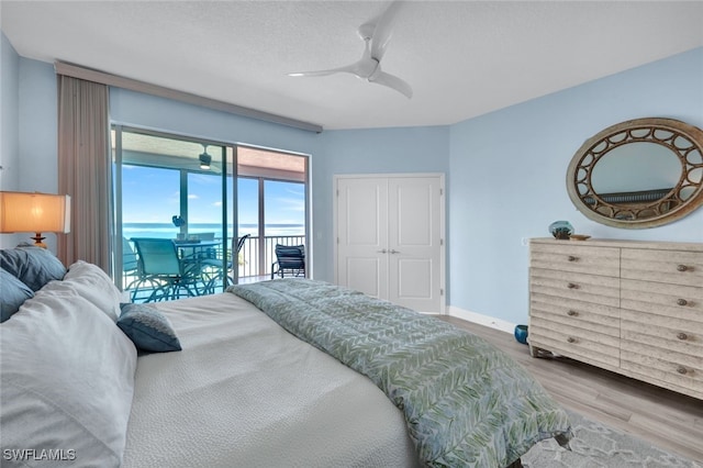 bedroom with a textured ceiling, access to outside, a closet, hardwood / wood-style flooring, and ceiling fan