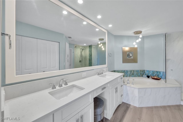 bathroom with independent shower and bath, vanity, and wood-type flooring