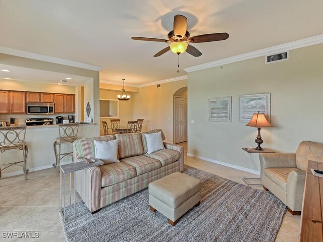 living room with light tile patterned flooring, ornamental molding, and ceiling fan with notable chandelier