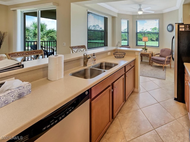 kitchen with a sink, light countertops, appliances with stainless steel finishes, brown cabinetry, and crown molding