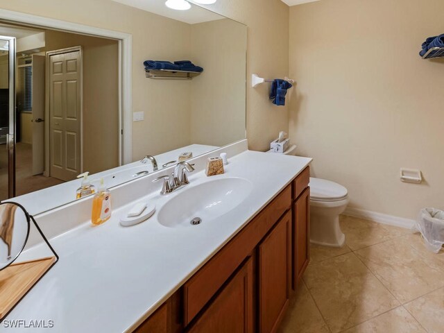 bathroom with tile patterned flooring, vanity, and toilet