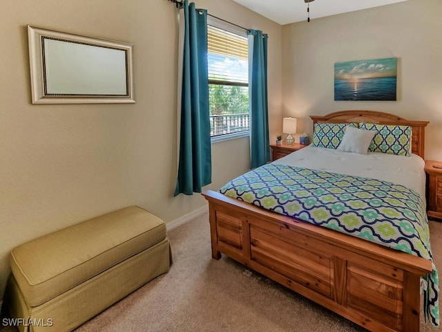 bedroom featuring light carpet and baseboards