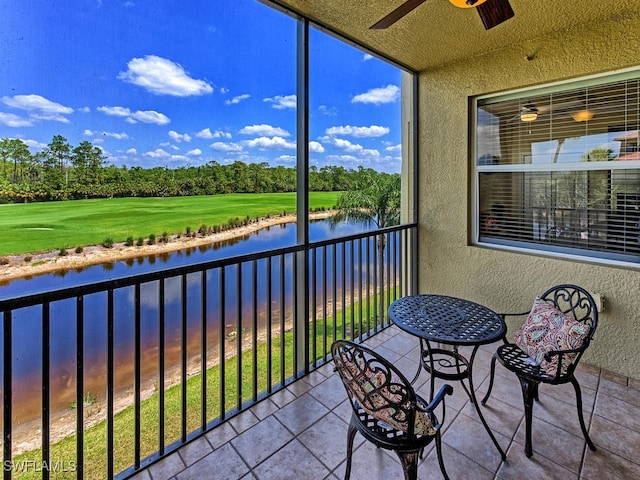 sunroom featuring a water view and ceiling fan