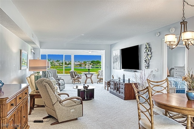 living room featuring a notable chandelier, light carpet, and a textured ceiling