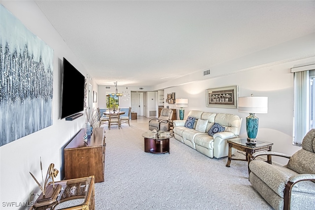 carpeted living room with an inviting chandelier