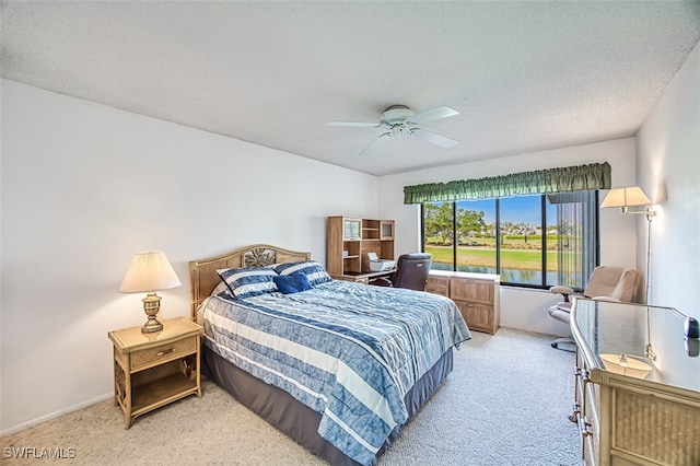 bedroom featuring ceiling fan, carpet, and a textured ceiling