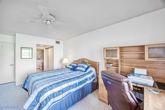 bedroom featuring ceiling fan, connected bathroom, and light carpet